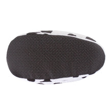Plush cow slipper turned upside down to show sole with non-slip grips