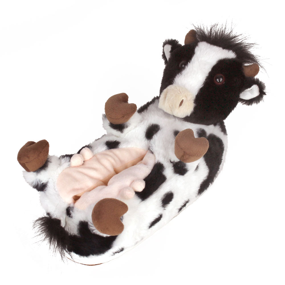 Plush cow slipper with black and white spotted plush, brown hooves, horns, eyes, little furry ears, and pink udder.