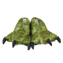 Pair of plush green dinosaur feet slippers with black claws on a white background
